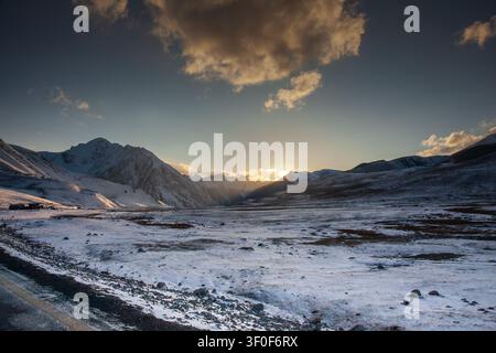 Blick auf die schneebedeckte Landschaft in der Nähe des Khunjerab-Passes bei Sonnenuntergang entlang der Karakorum-Hochstraße in Hunza, Gilgit, Pakistan. Stockfoto