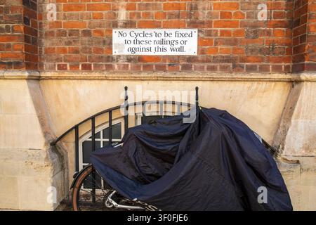 Schild mit der Aufschrift „Fahrräder dürfen nicht an den Geländern oder an dieser Wand befestigt werden“ mit einem geparkten Fahrrad. Stockfoto
