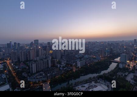Stadtansicht von Chengdu in der Dämmerung mit Fluss und beleuchteten Gebäuden Stockfoto
