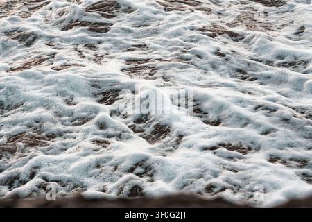 Nahaufnahme von Meeresblasen und Wassertextur, die einen dynamischen und spannungsgeladenen natürlichen Hintergrund einfangen. Stockfoto