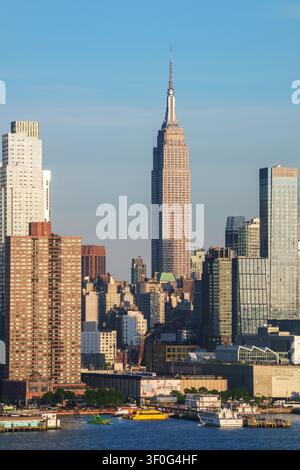 Empire State Building erhebt sich über der Skyline von New York City und den Wolkenkratzern von Manhattan auf der anderen Seite des Hudson River, New York, USA. Stockfoto
