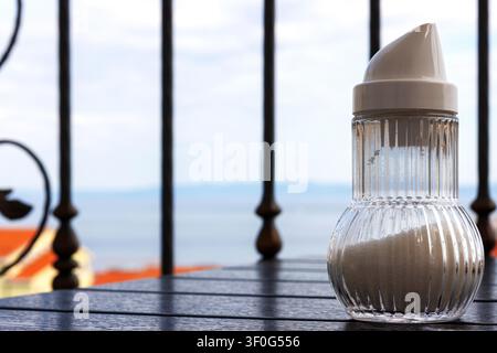 Gläserner Zuckerdose auf einem Balkonfrühstückstisch mit Blick auf die Adria in Makarska, Kroatien Stockfoto