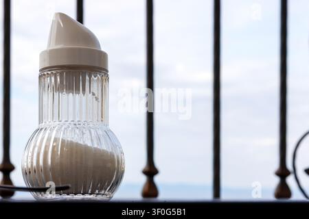Gläserner Zuckerdose auf einem Balkonfrühstückstisch mit Blick auf die Adria in Makarska, Kroatien Stockfoto