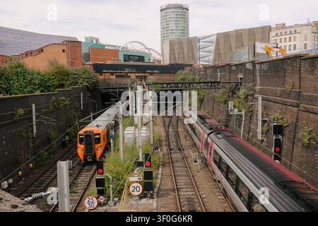 CrossCountry-Zug nähert sich dem Bahnhof Birmingham New Street mit der Skyline der Rotunde und des Bullrings, UK Stockfoto