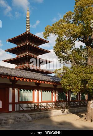 Vertikale Niedrigwinkelaufnahme, die direkt nach oben auf die zinnoberroten Stockwerke des historischen fünfstöckigen Pagoden des Shitenno-ji-Tempels in Osaka, Japan, blickt Stockfoto