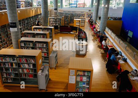 Hohe Blickwinkelansicht von Menschen und Studenten, die Laptops benutzen und in der Bibliothek von Birmingham, UK, lesen Stockfoto