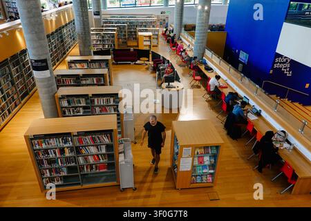 Hohe Blickwinkelansicht von Menschen und Studenten, die Laptops benutzen und in der Bibliothek von Birmingham, UK, lesen Stockfoto