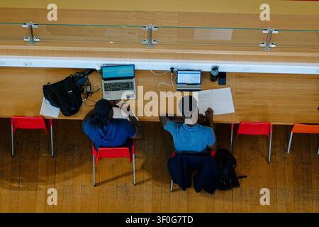 Hohe Blickwinkelansicht von Menschen und Studenten, die Laptops benutzen und in der Bibliothek von Birmingham, UK, lesen Stockfoto