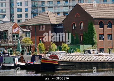 Narrowboats, die am Gas Street Basin festgemacht sind, mit The Botanist Bar und historischen Backsteingebäuden in Birmingham, UK Stockfoto