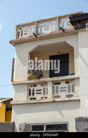 Bemalte Statuen auf einem verwitterten Balkon, Elmina, Ghana Stockfoto