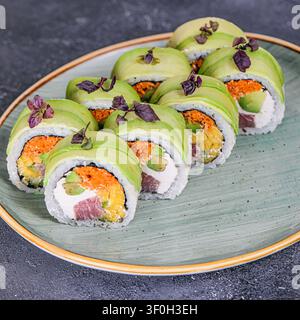 Eine Nahaufnahme eines Tellers mit einer Vielzahl köstlicher Sushi-Rollen, die ordentlich angeordnet sind. Stockfoto