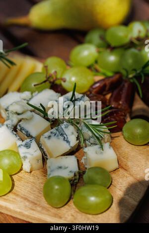 Gourmet-Käse- und Obstplatte auf Holztablett.. Stockfoto