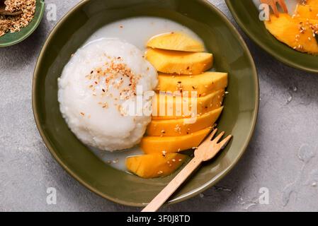 Thailändischer Klebreis mit Mango in Kokosmilch mit gerösteten Sesamsamen. Oberansicht. Selektive Fokussierung Stockfoto