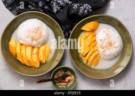 Thailändischer Klebreis mit Mango in Kokosmilch mit gerösteten Sesamsamen. Oberansicht. Selektive Fokussierung Stockfoto