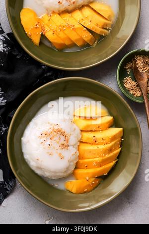 Thailändischer Klebreis mit Mango in Kokosmilch mit gerösteten Sesamsamen. Oberansicht. Selektive Fokussierung Stockfoto