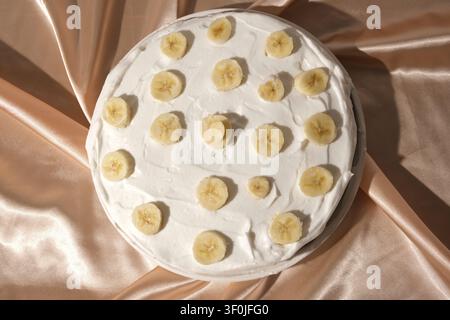 Nahaufnahme eines köstlichen Bananen-Kremkuchens mit frischen Obstbelägen Stockfoto