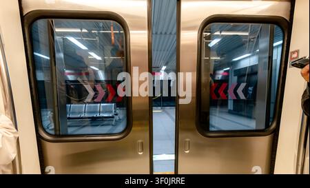 Nahaufnahme der U-Bahn-Türen in Kaohsiung auf einem U-Bahn-Stationstrebn in Taiwan, die moderne Metro-Innenreflexionen, Sicherheitsmarkierungen und Stockfoto