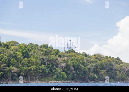 Null-Kilometer-Monument von Indonesien erhebt sich über einem üppigen tropischen Wald auf Pulau Weh, Indonesien, mit Blick auf eine felsige Küstenlinie unter einem strahlend blauen Himmel und Stockfoto