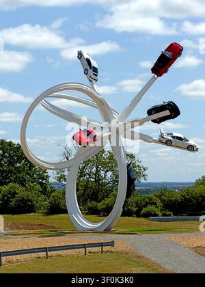 Porsche 911 Autos, die auf Gerry Judahs 21-Meter-Loop-Skulptur im Porsche Experience Centre in Silverstone montiert sind Stockfoto