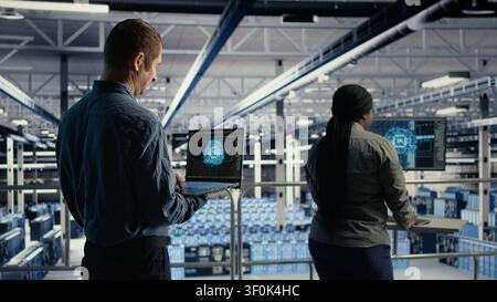 Der Administrator des Rechenzentrums verwendet einen Laptop, um Deep Learning-Prozesse zu überwachen und mit KI-Technologie und Hochleistungssystemen zu arbeiten. Stockfoto