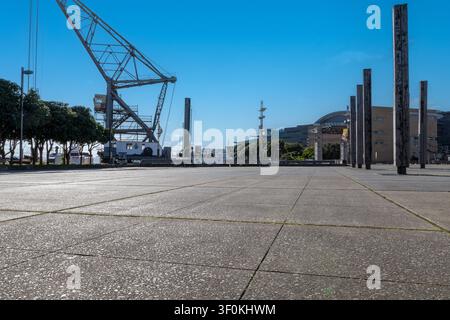 Autohintergrund, Automobil-Rückplatte, großer gepflasterter Parkplatz mit Hafen im Hintergrund Stockfoto