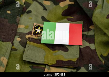 Italienische Flagge auf einem Tarnmuster-Hintergrund einer Militäruniform. Stockfoto