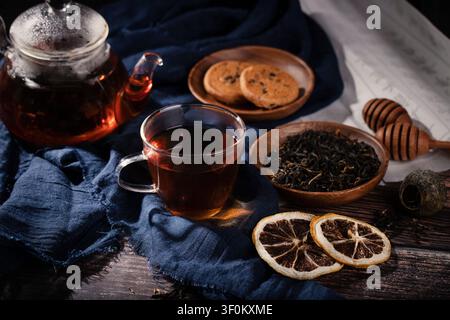 Traditionelle chinesische Teezeremonie mit schwarzem Tee in Glasbecher und Kanne auf Holztablett Stockfoto