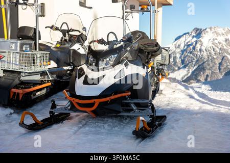 Vorderansicht großer moderner Schneemobil-Roller atv alpines Bergresort vor sonnigem Himmel an kalten, schneereichen Wintertagen. Schneemobilverleih Sportabenteuer Stockfoto