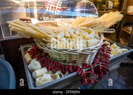 Ein hölzernes Tablett an der Theke einer italienischen Delikatessenhandlung oder Trattoria präsentiert verschiedene Sorten von roher Trockenpasta, darunter Rigatoni, Spagh Stockfoto