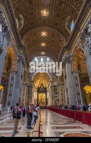 Das große zentrale Schiff der St. Petersbasilika erstreckt sich hin zu Berninis ikonischem Bronzebaldachin und dem päpstlichen Altar unter Michelangelos Kuppel. Stockfoto