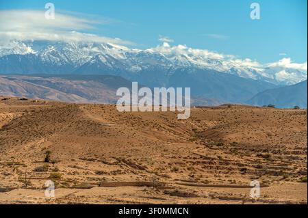 Weite Teile der Agafay-Wüste zeigen weit entfernte schneebedeckte Berge in Marokko Stockfoto