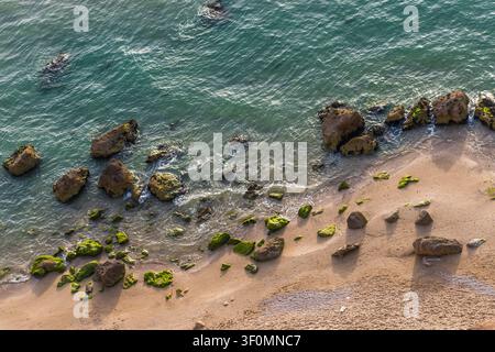 Eine Luftperspektive zeigt einen rauen Sandstrand entlang der Algarve-Küste in Südportugal. Stockfoto