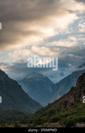 Ein tiefes Bergtal schneidet zwischen steilen bewaldeten Kammlinien im Großen Kaukasus. Stockfoto