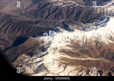 Eine Luftperspektive fängt die schneebedeckten Kammlinien und tief erodierten Täler des Großen Kaukasus über Dagestan, Russland, ein. Stockfoto