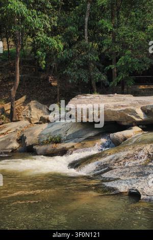CHIANG MAI, THAILAND - 15. APRIL 2026: Eine vertikale Hochwinkelaufnahme eines kleinen, schnell fließenden Flusses, der durch große graue Felsen und Geröllsteine fließt Stockfoto