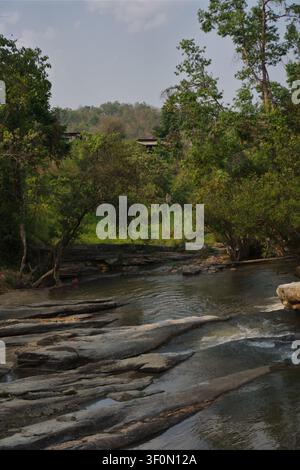 CHIANG MAI, THAILAND - 15. APRIL 2026: Eine vertikale Hochwinkelaufnahme eines kleinen, schnell fließenden Flusses, der durch große graue Felsen und Geröllsteine fließt Stockfoto