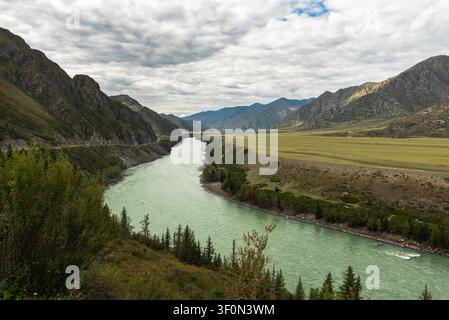 Erhöhte Ansicht über die türkisfarbenen Gletscherewässer des Katun-Flusses, der sich durch ein breites Bergtal in der Republik Altai, Russland, schlängelt. Stockfoto