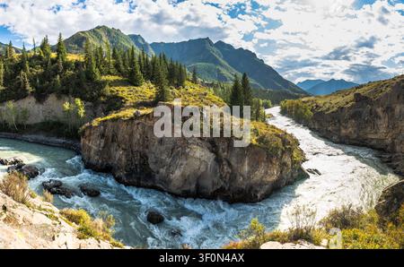 Eine dramatische Felsinsel teilt den türkisfarbenen Katun in zwei Wildwasserströme innerhalb eines rauen Bergtals in der Republik Altai, Russland. Stockfoto