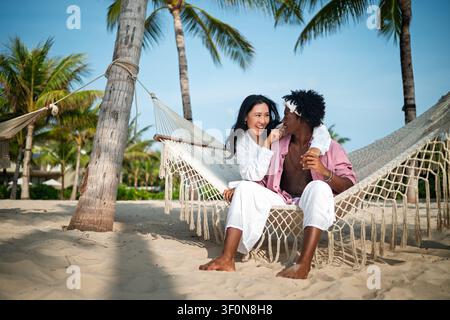 Reines Glück. Ein junges, vielseitiges, multiethnisches Paar genießt jeden Moment ihres tropischen Urlaubs Stockfoto