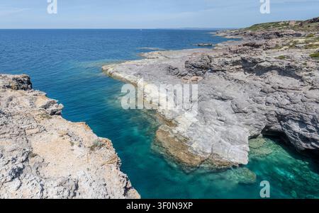 panoramische Landschaft mit schmalem felsigen Einschnitt und klarem blauem Wasser an der Bucht Cala Grotta an der Mittelmeerküste, bei hellem Licht auf der Insel Sant Antioco aufgenommen Stockfoto