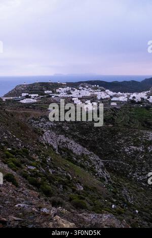 Fernblick auf Chora mit weiß getünchten Häusern, Windmühlen, terrassierten Feldern, felsigen Bergen und der Ägäis bei Einbruch der Dunkelheit auf der Insel Amorgos in den Kykladen Stockfoto