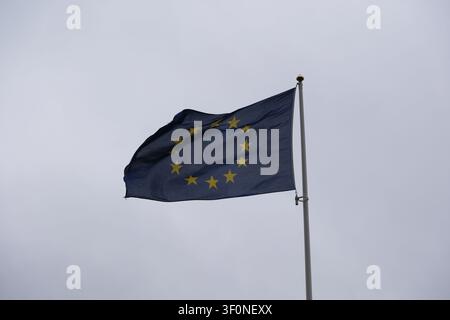 Die Flagge der Europäischen Union weht an einer Flaggenstange vor einem bewölkten Himmel. Stockfoto