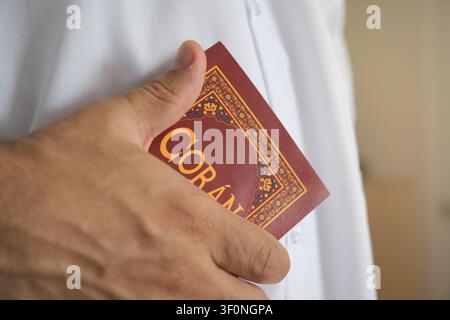 Hand, die den heiligen Quran hält, repräsentiert islamischen Glauben und Spiritualität Stockfoto