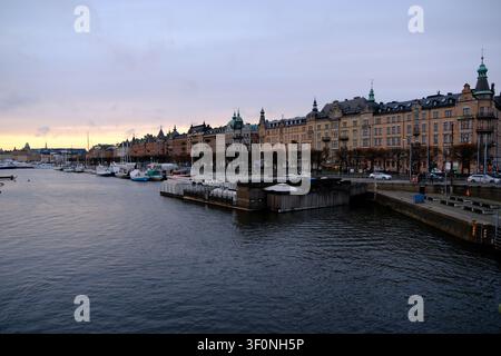 Stockholm, Schweden-28. Nov. 2025: Dämmerungsansicht historischer Gebäude entlang der Strandvägen und des Ladugårdslandsviken-Hafens in Stockholm Stockfoto