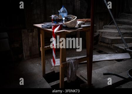 Innenansicht der feuergeschädigten Struktur mit einem Arbeitstisch, Sicherheitshelm, Gerüst und freiliegendem Holz im Inneren der Maison de la Mere Pourcel con Stockfoto