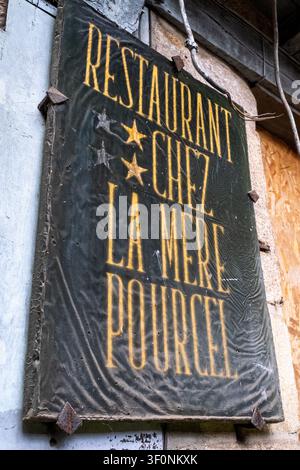 Nahaufnahme eines alten dunkelgrünen Restaurantschildes mit goldener Aufschrift RESTAURANT CHEZ LA MERE POURCEL, das an einer Steinmauer an der Conserva montiert ist Stockfoto