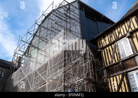 Außenansicht der Rekonstruktionsstätte Maison de la Mere Pourcel mit umfangreichem Metallgerüst, schützenden Netzvorhängen und blauen Lagerfässern und Stockfoto