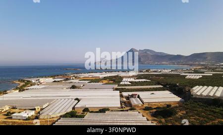 Gewächshäuser entlang der Küste von Falasarna Beach, die Landwirtschaft auf Kreta, Griechenland, mit dem Mittelmeer und den Bergen ausweitend Stockfoto