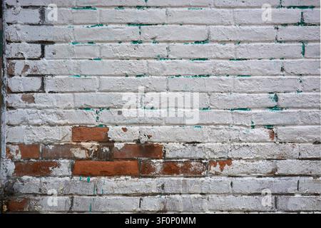 Alte Ziegelwandtextur mit abblätternder weißer Farbe und freigelegtem rotem Ziegel Stockfoto