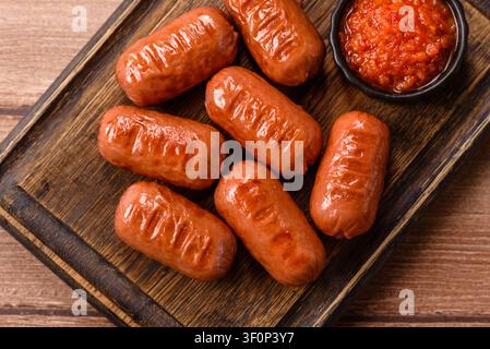 Grillwürste mit Hühnchen oder Schwein, Knoblauch, Salz und Gewürzen. Grillen von Würstchen als kulinarischer Hintergrund für Ihr Design Stockfoto